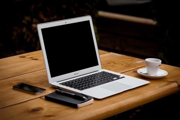 Close up shot of a high end laptop keyboard and screen displaying lines of complex code and data structures, clean aesthetic, no human figures